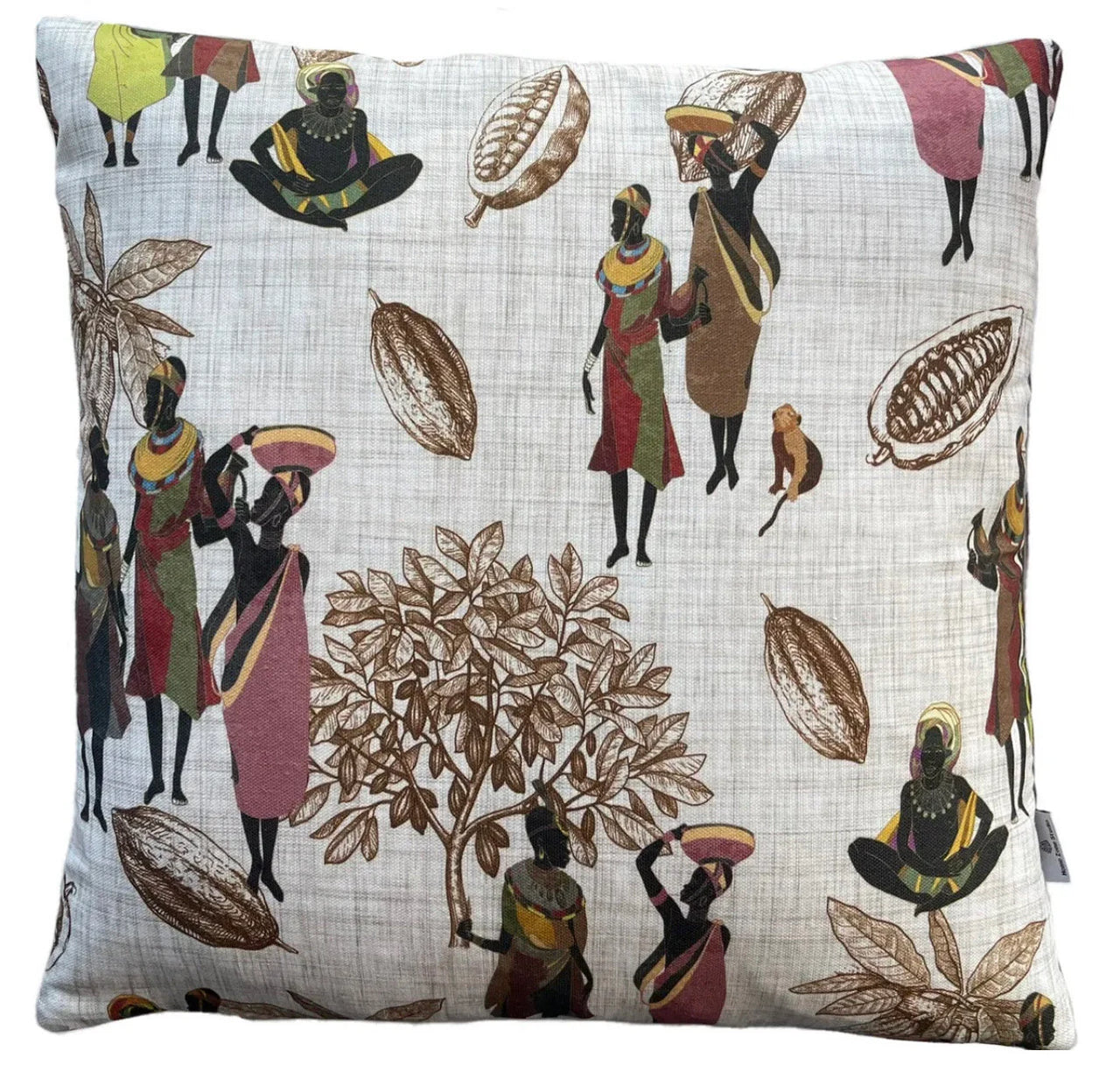 Decorative pillow with African-themed design featuring people and cocoa beans on a white background.