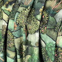 Thumbnail for Close-up of fabric with a nature-themed pattern featuring trees and plants.