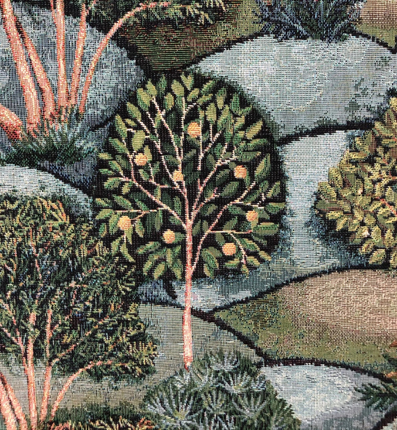 Close-up of a tapestry with a detailed landscape design featuring trees and rocks.