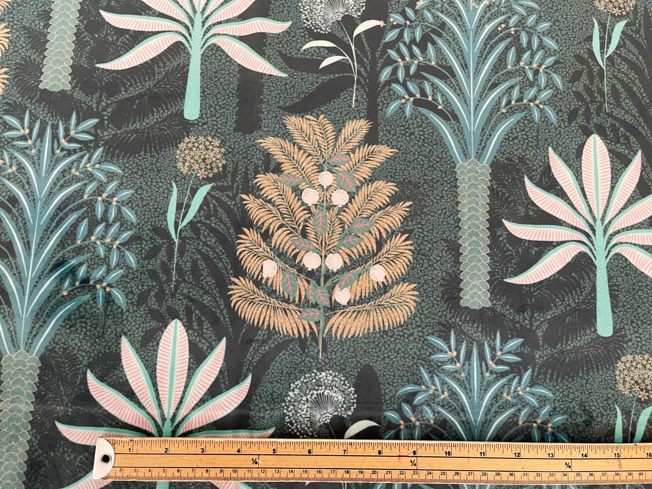 Jungle-themed fabric with plants and a ruler for scale on a dark background