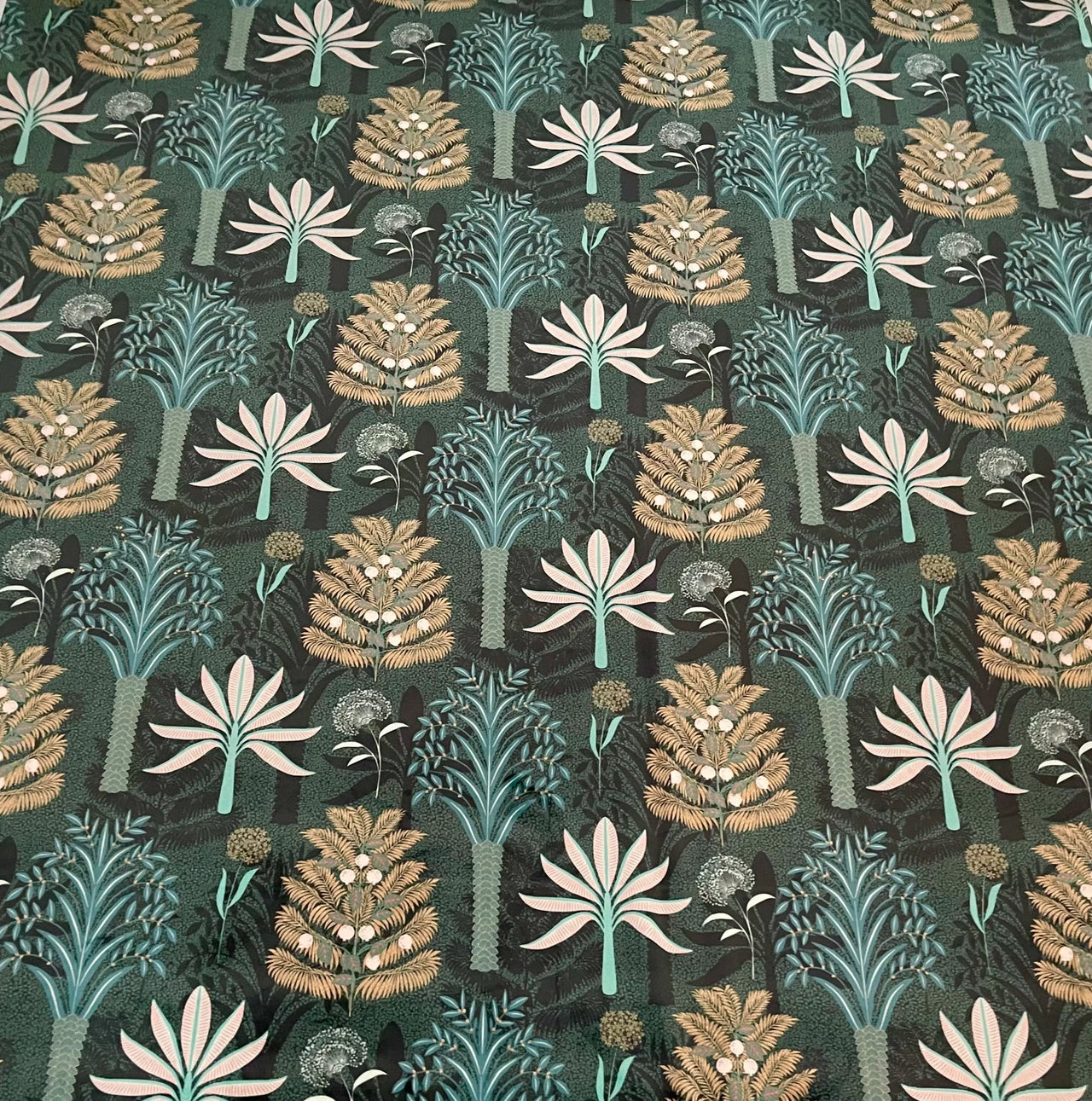 Patterned fabric with stylized trees and plants on a dark green background