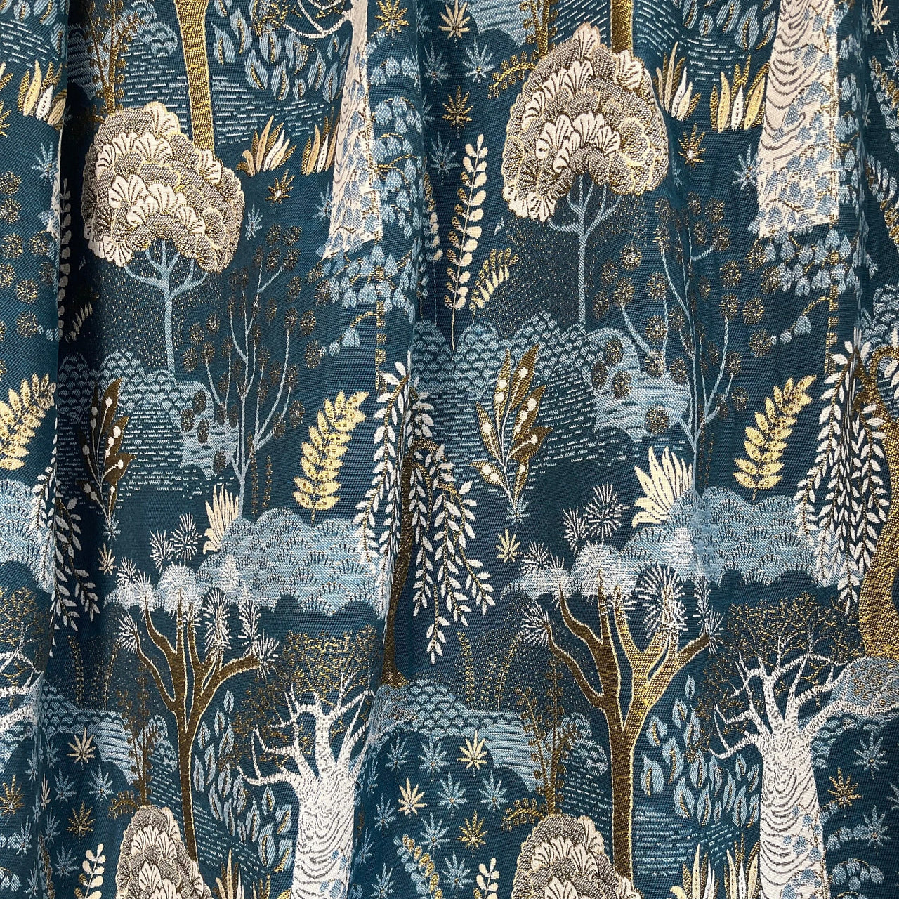 Baobab Tree of Life woven fabric draped to show pattern and texture in luxurious blue and gold tones
