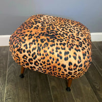 Thumbnail for Round ottoman with leopard print pattern on a wooden floor.