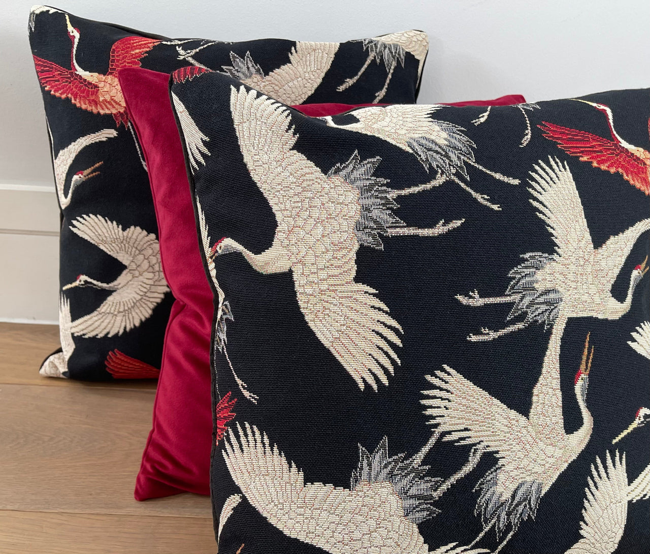 Flying crane decorative pillow on wooden floor.

