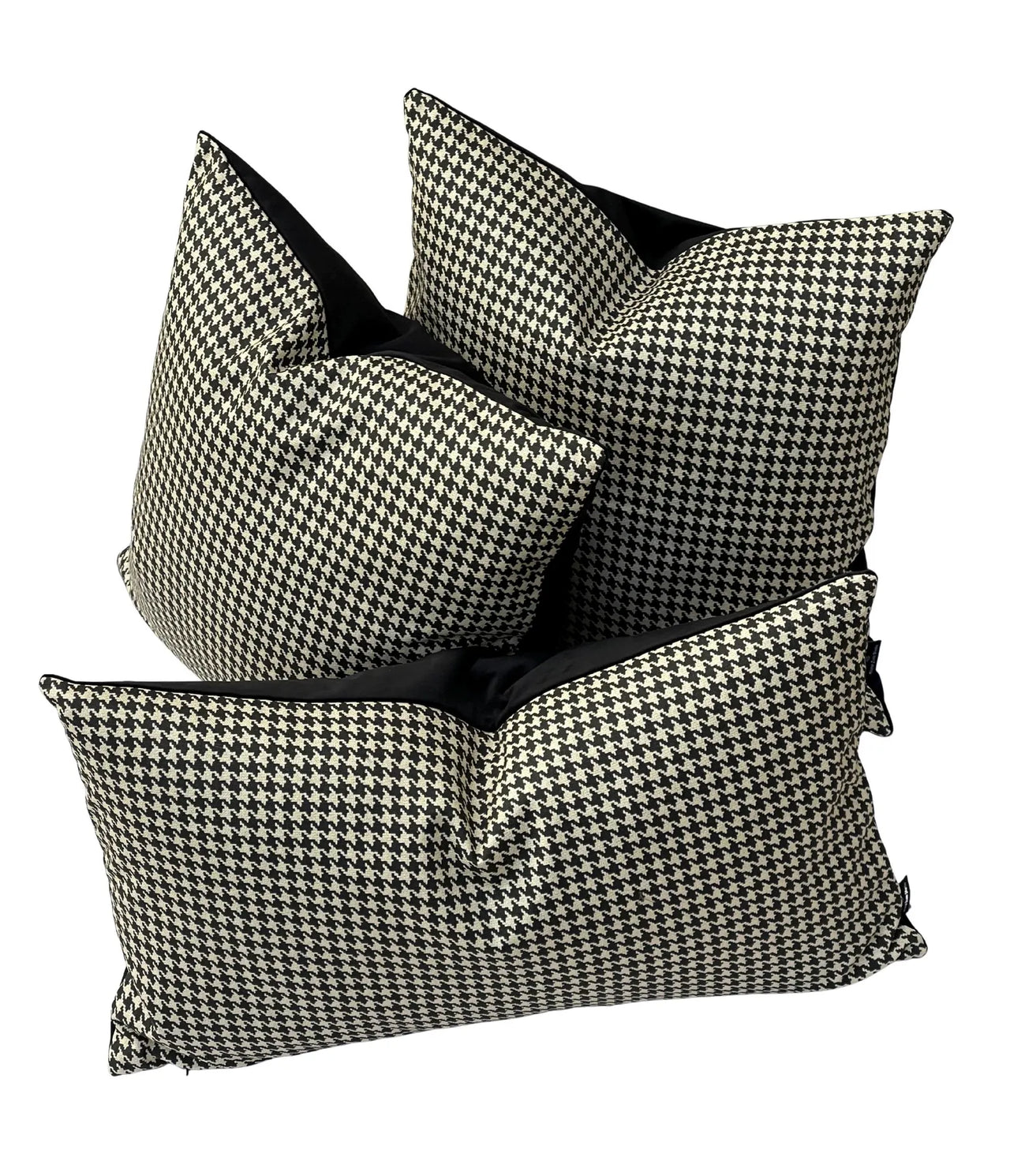 Three houndstooth patterned pillows with black accents on a white background