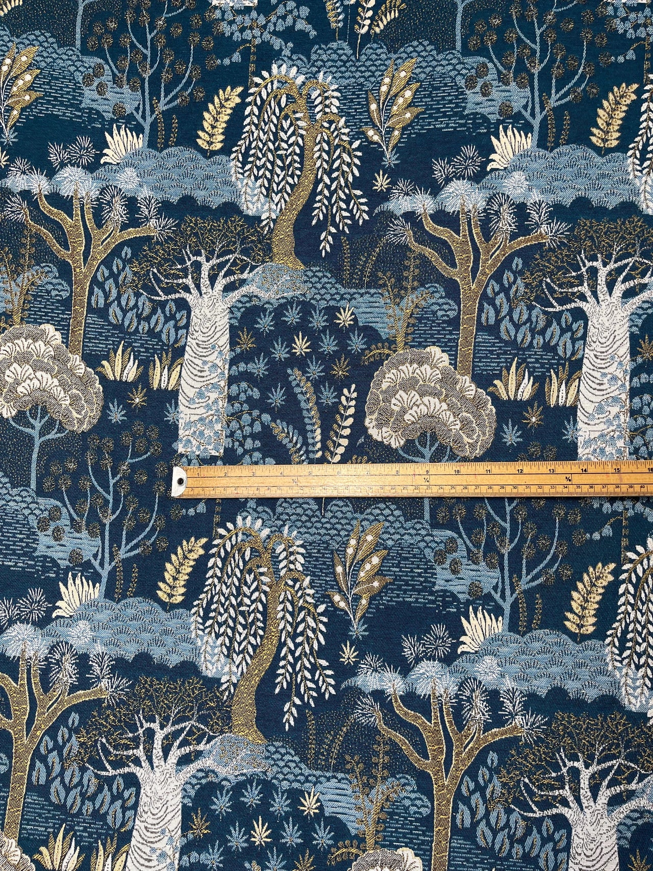 Folksy forest pattern with trees and foliage on a blue background, featuring a ruler for scale.
