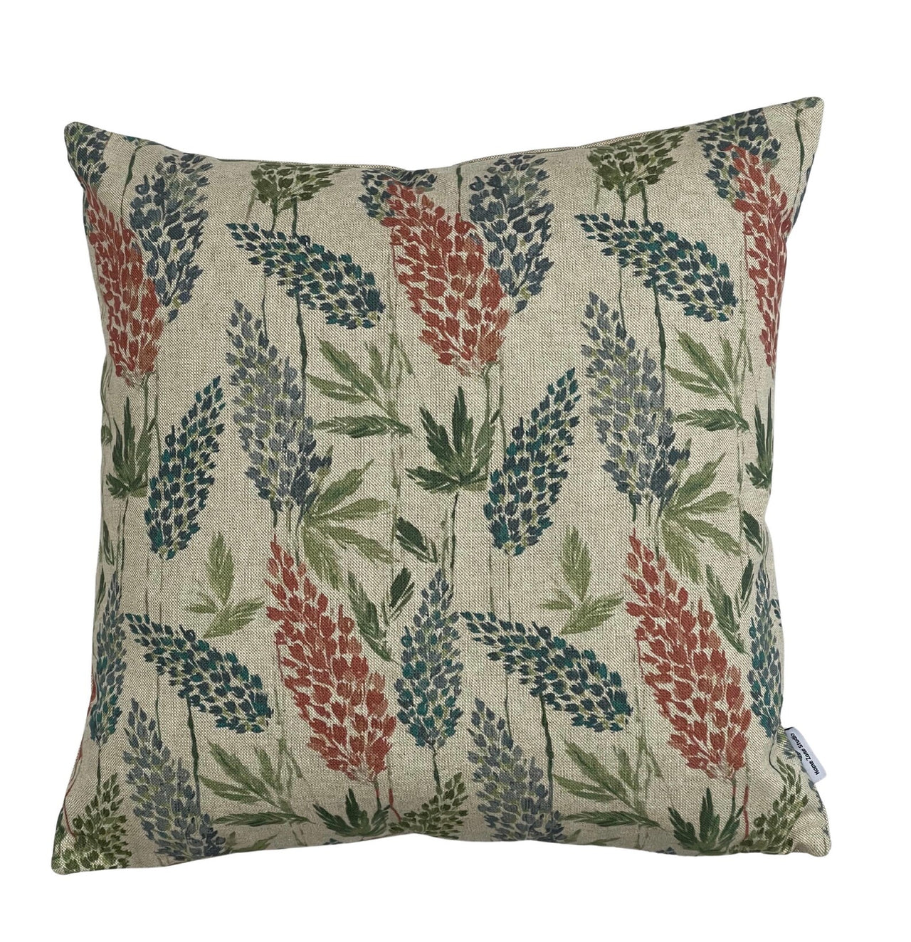 Decorative pillow with floral pattern on a beige background Close-up of sap green leaves and indigo florals on oatmeal ground.
