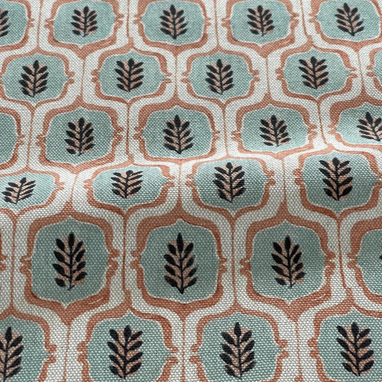 Repeating medallion trellis fabric in teal and terracotta.