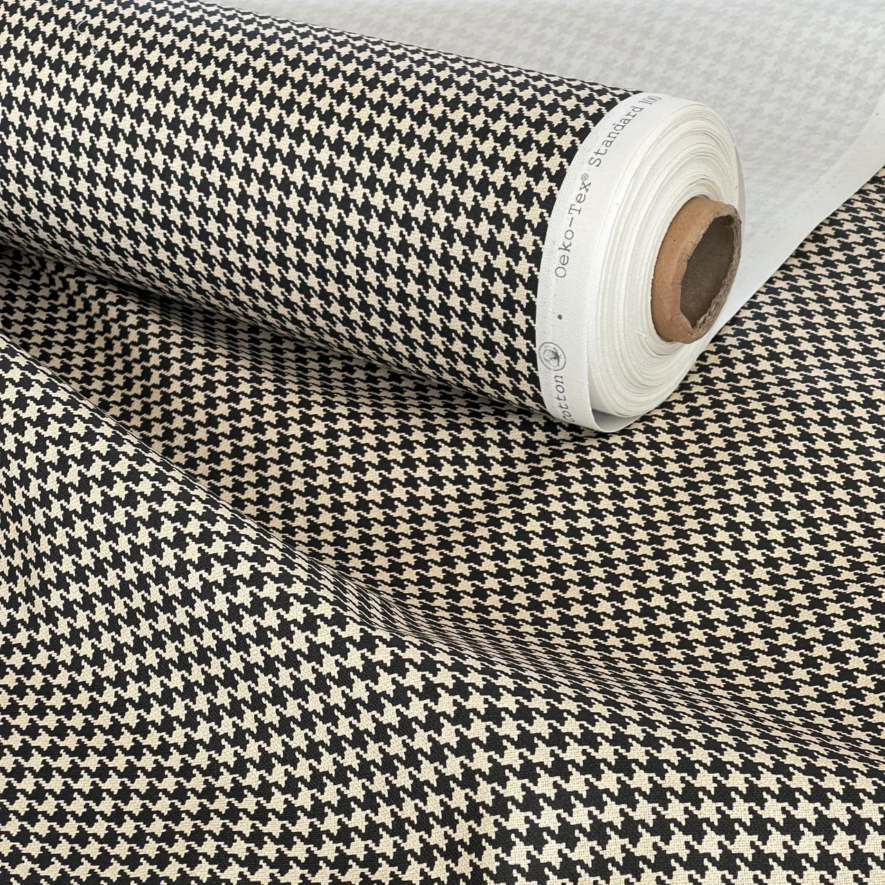 Printed houndstooth fabric in neutral tones – organic cotton roll ideal for soft furnishings, accent chairs, and slow design interiors.

