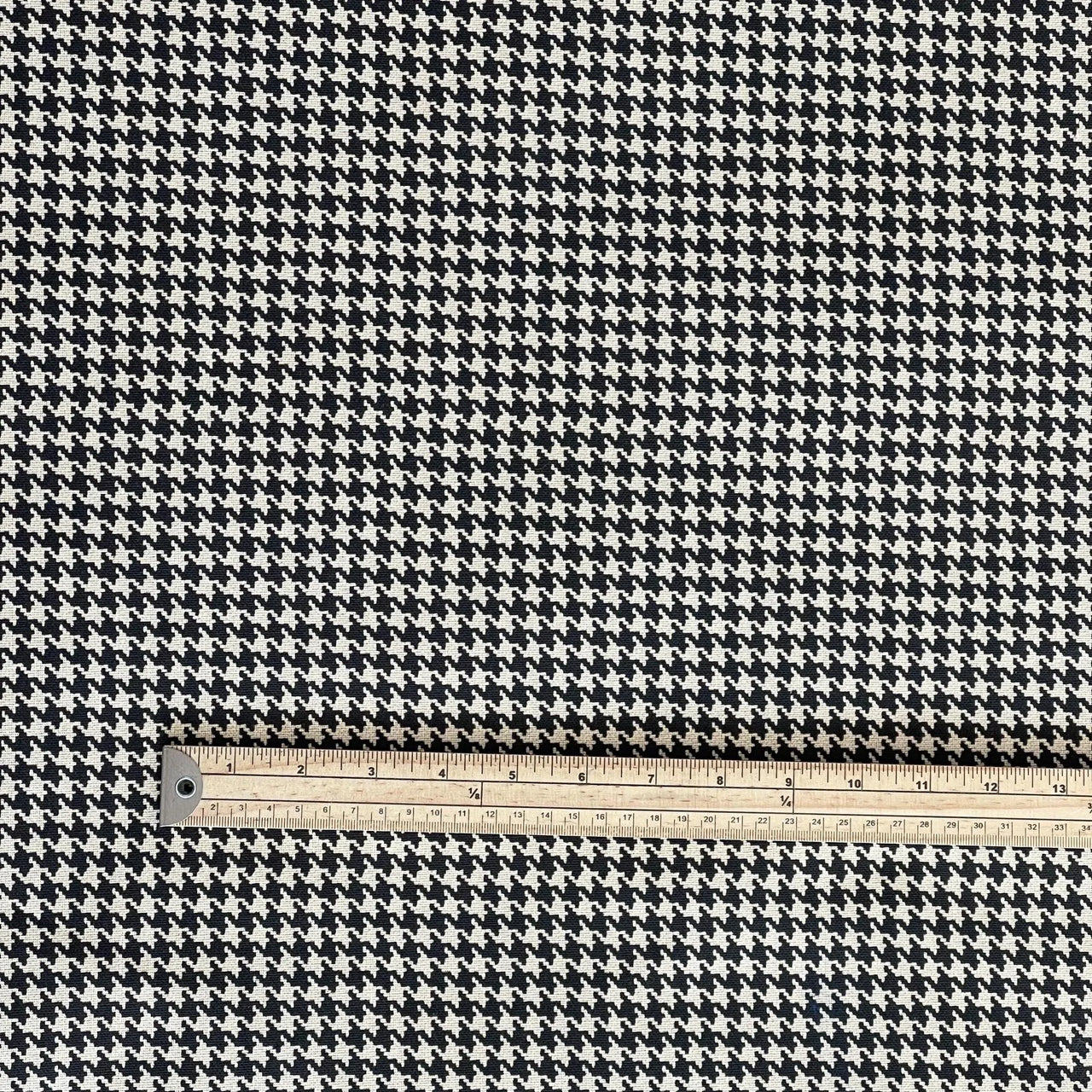Close-up of mini houndstooth print with scale measurement – organic cotton fabric for precision projects and upholstery detail work.

