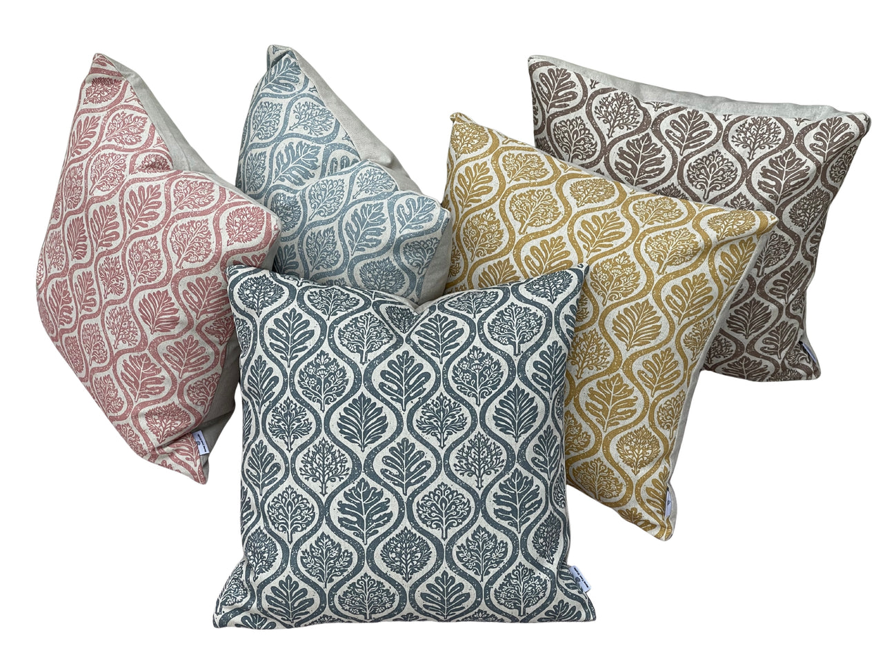 Coordinated decorative cushions in ochre, pink, blue and taupe with linen look botanical fabric design