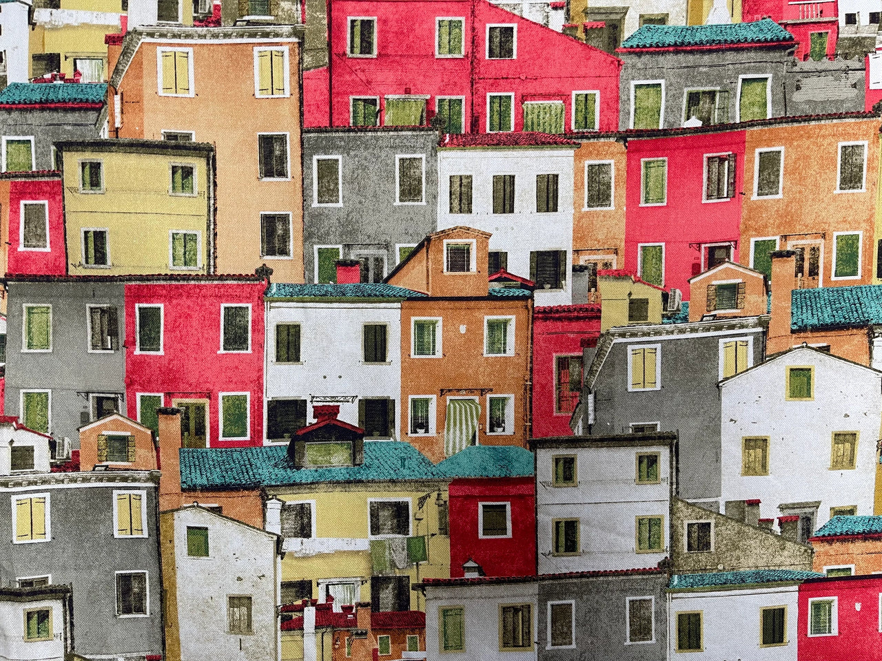 Digitally printed cotton fabric featuring colorful Positano village houses with red, yellow, terracotta, and white buildings stacked together.