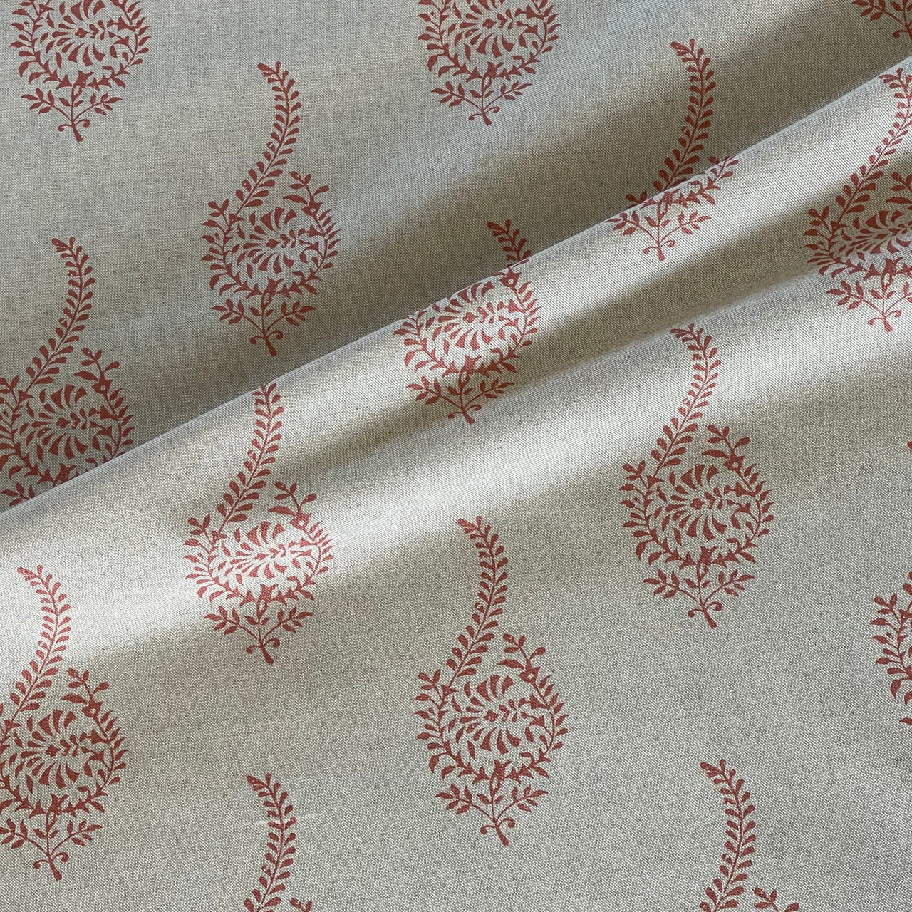 Close up coral paisley sprig pattern cotton blend fabric