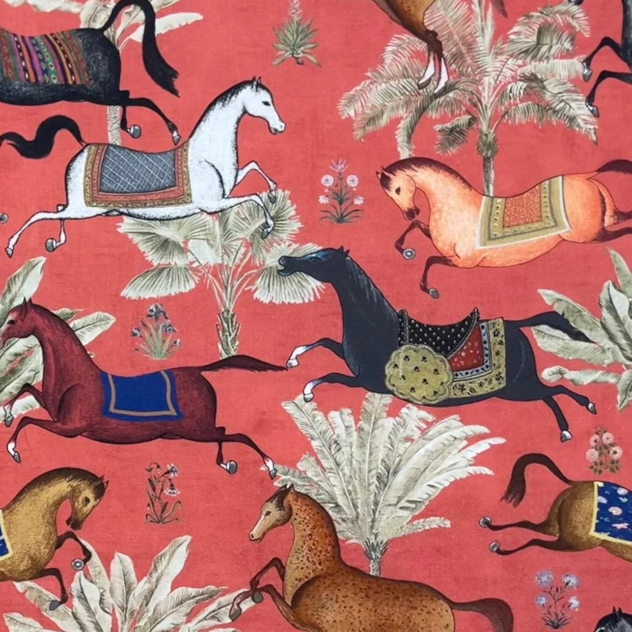 Patterned fabric with horses and palm trees on a red background