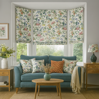 Thumbnail for Living room with floral window treatments, a blue sofa, and decorative pillows.
