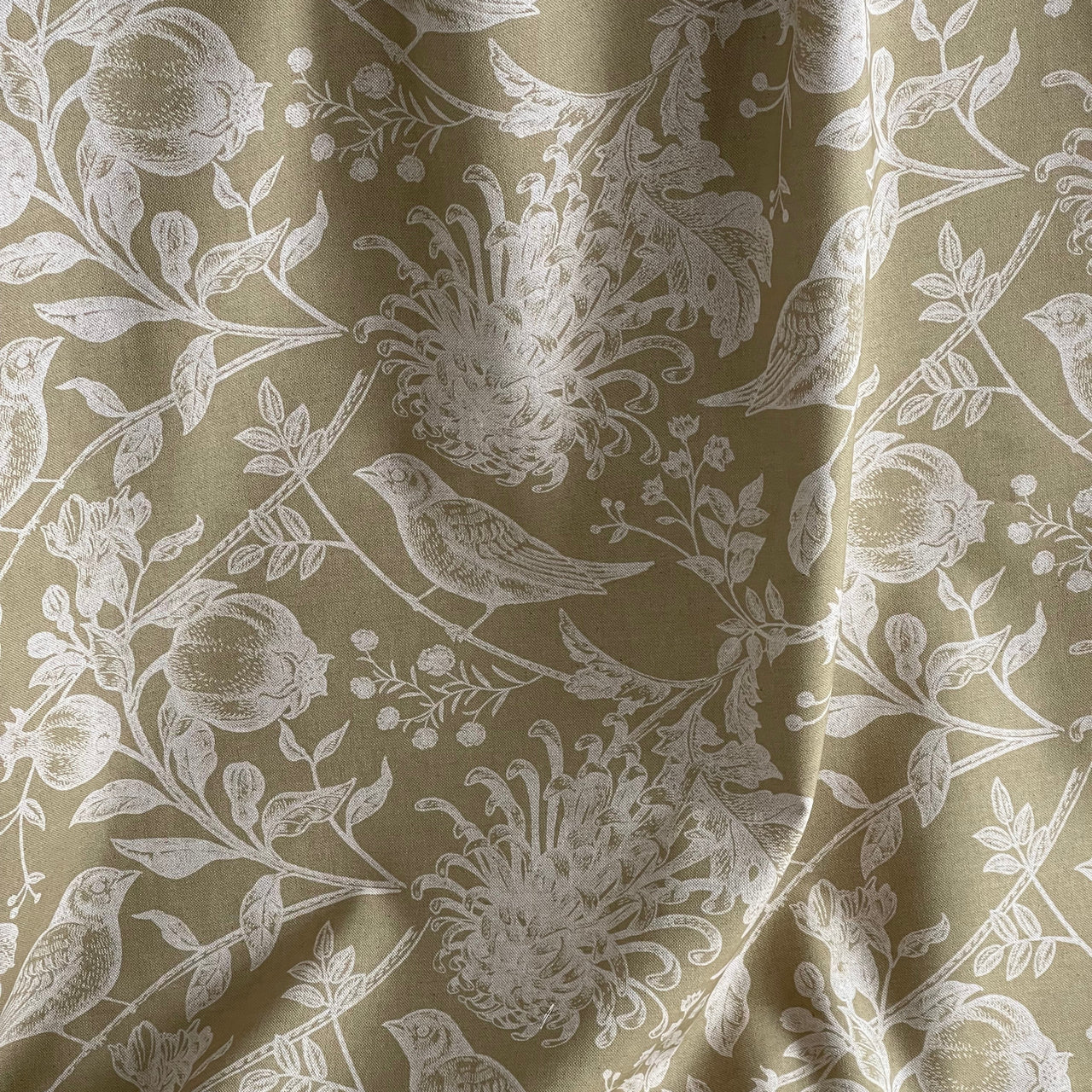 Floral patterned fabric with white flowers and leaves on a beige background