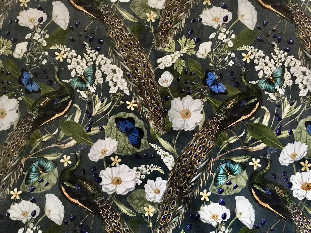 Patterned fabric with peacocks, flowers, and butterflies on a dark background