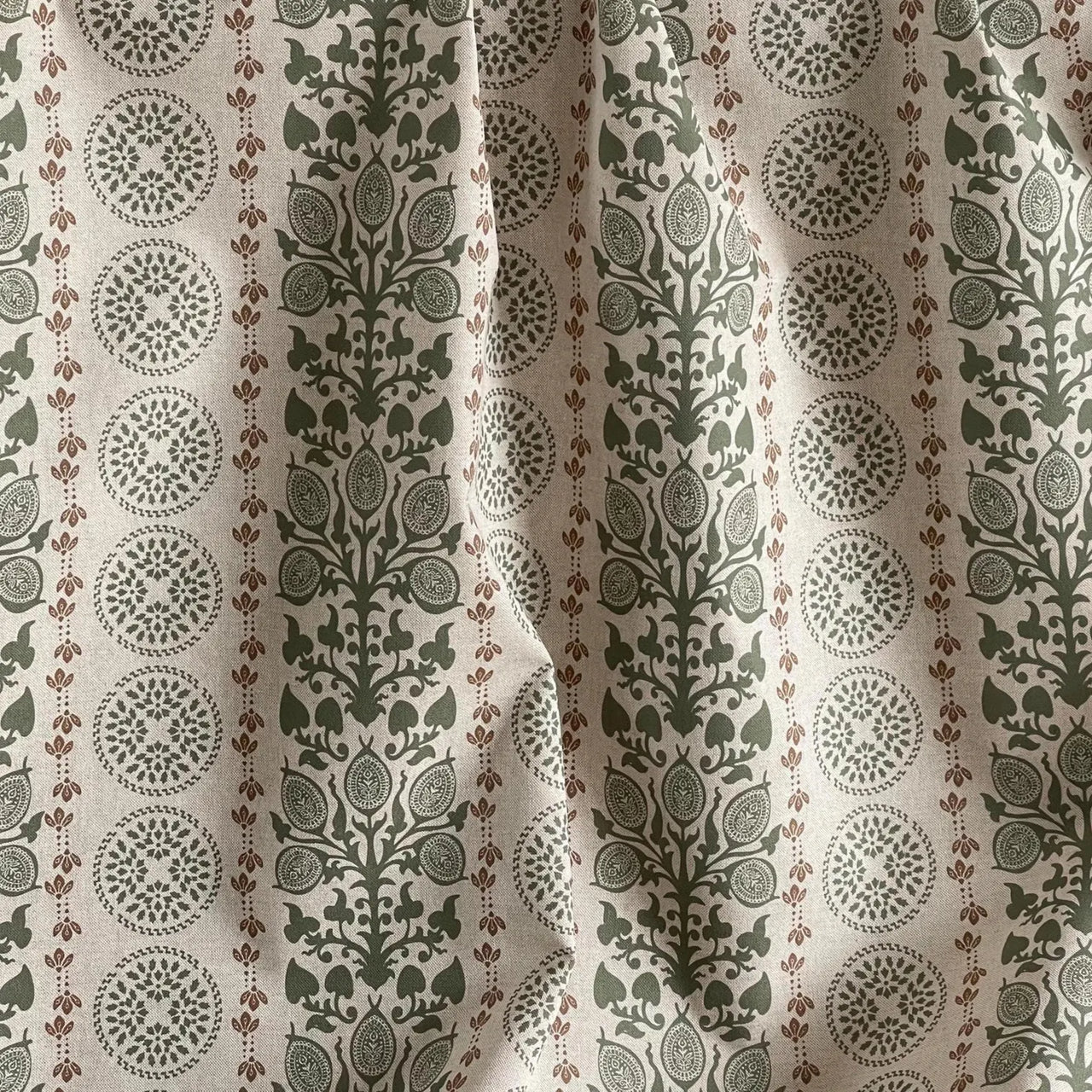 Folk inspired botanical fabric with sage green leaves and rust accents close detail