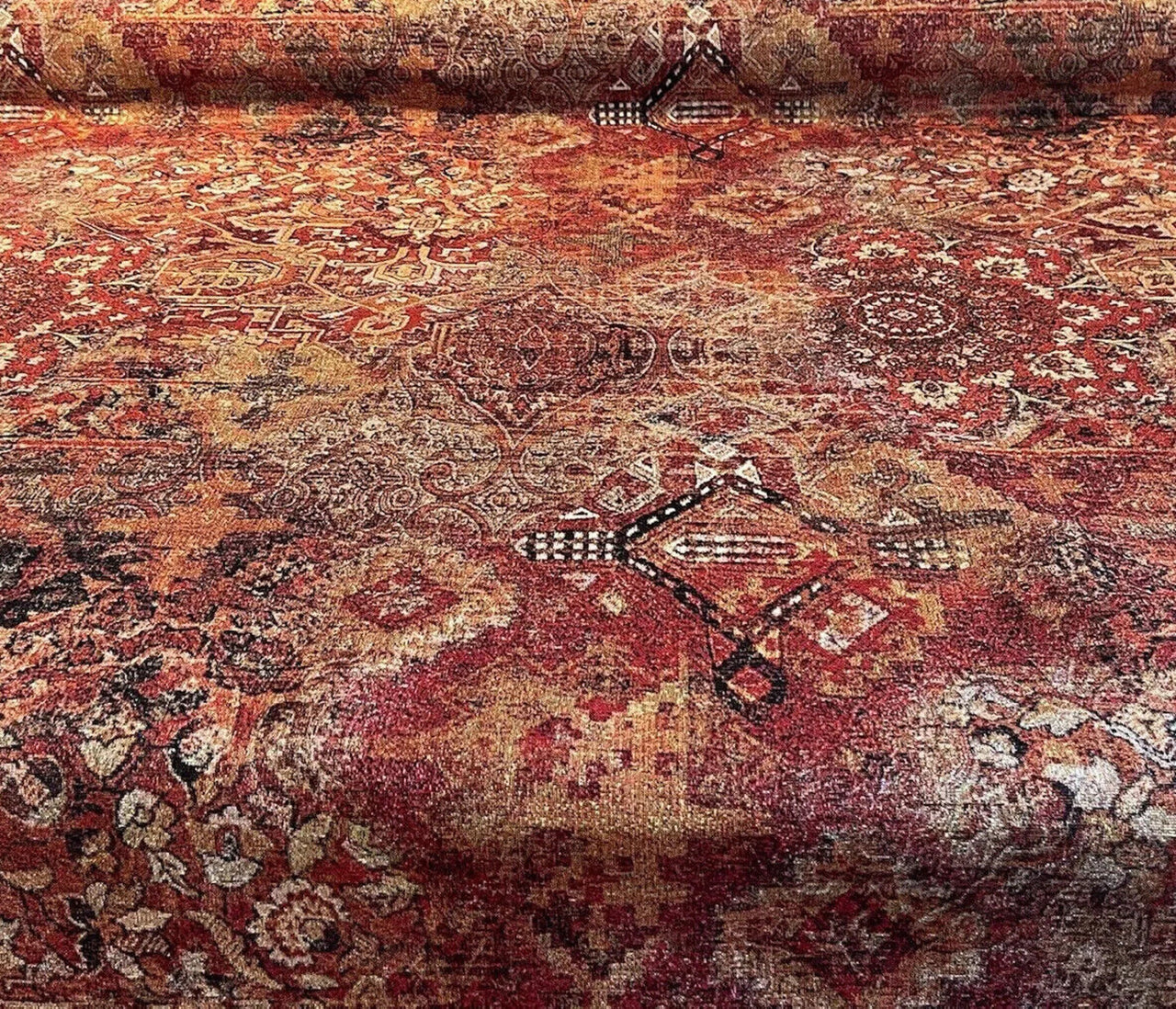 Close-up of woven oriental kilim tapestry fabric rolled out, showing textured details in red, gold, and terracotta