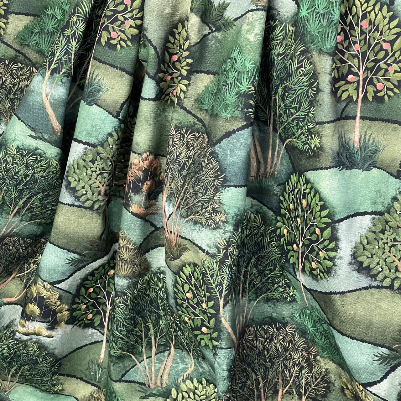 Fabric with a nature-themed design featuring trees and landscapes.