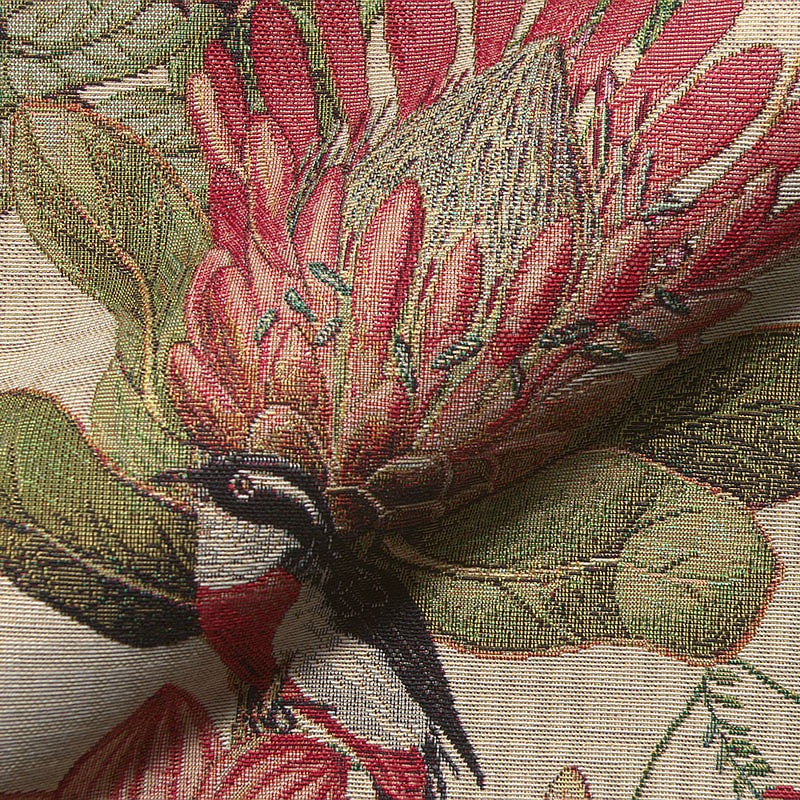 Close-up of botanical woven fabric with birds and flowers.