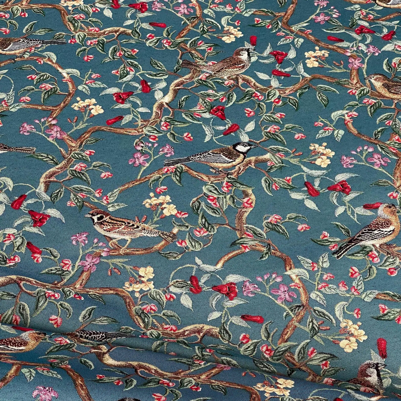 High-detail tapestry fabric showing birds on flowering branches