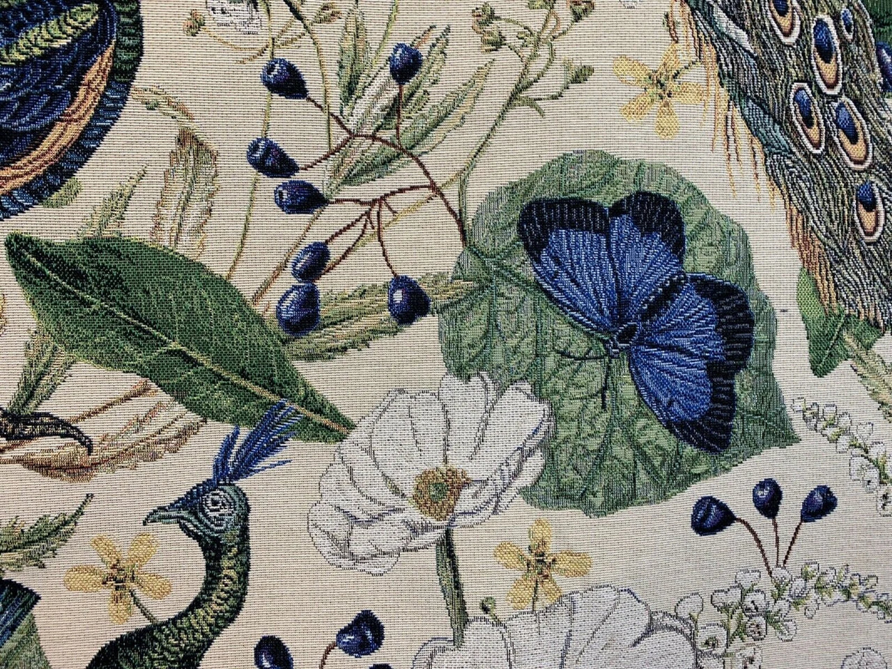 Embroidered design featuring peacocks, butterflies, and flowers on a beige background