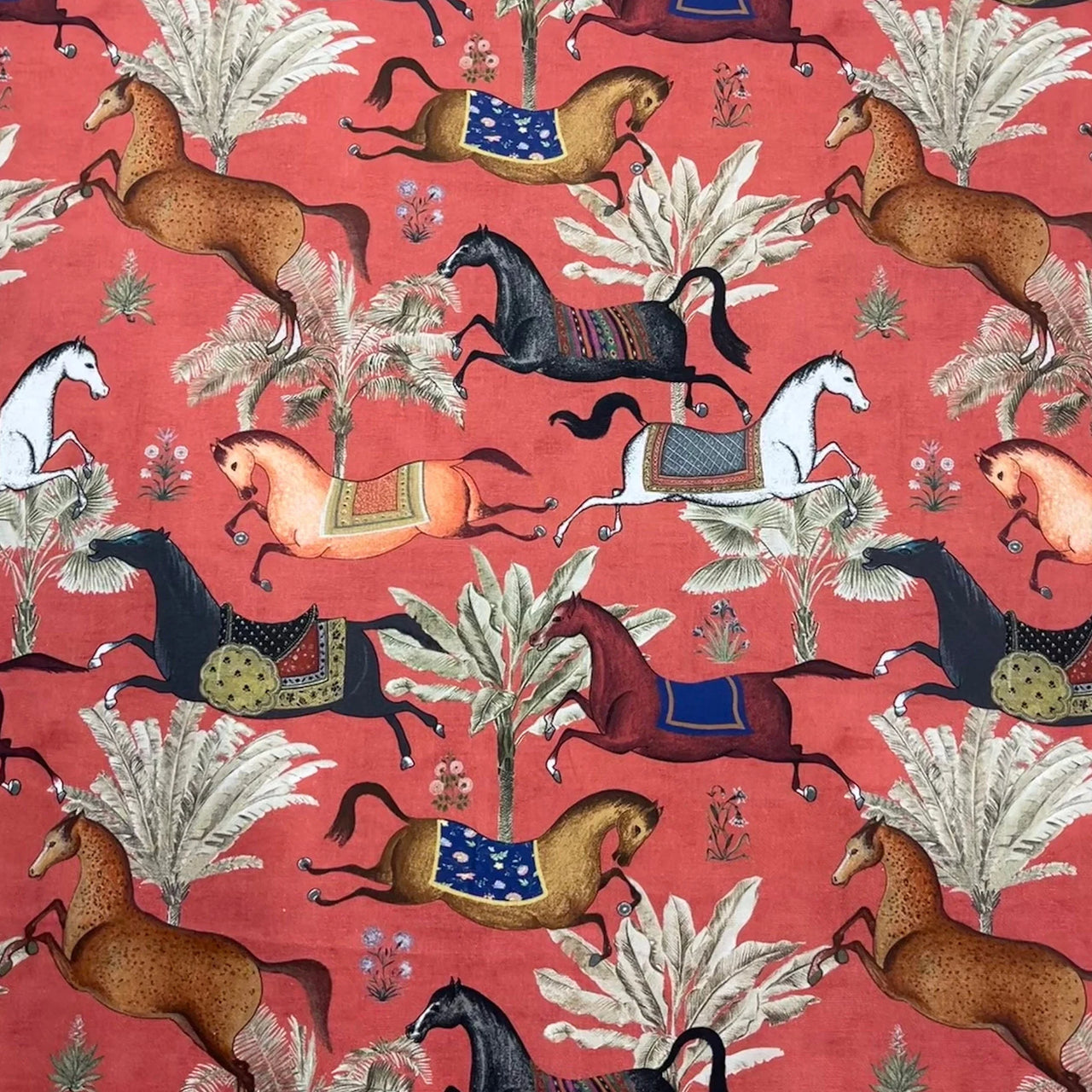 Patterned fabric with horses and plants on a red background