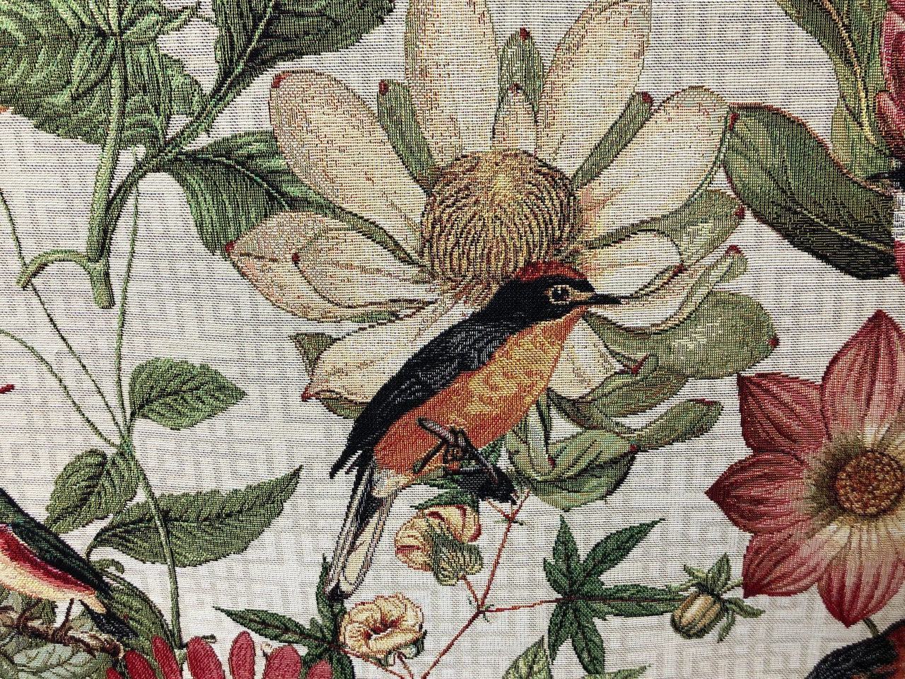 Floral and wildlife upholstery fabric in apricot tones.