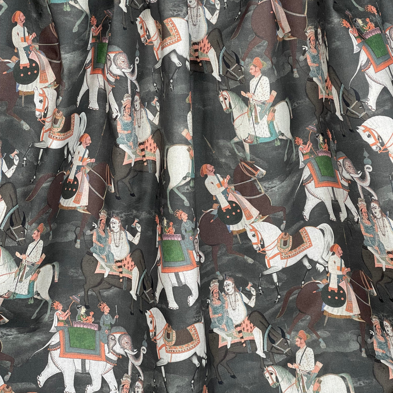 Patterned fabric with illustrations of people on horseback and other figures.