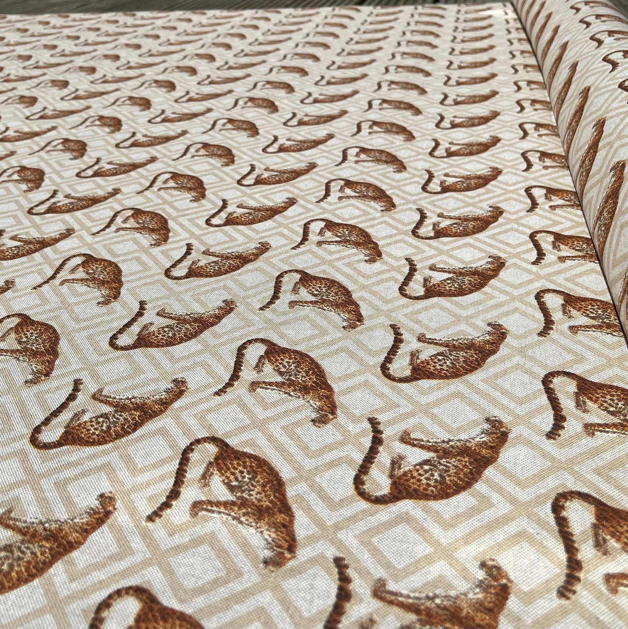 Patterned fabric with brown leopards on a beige background