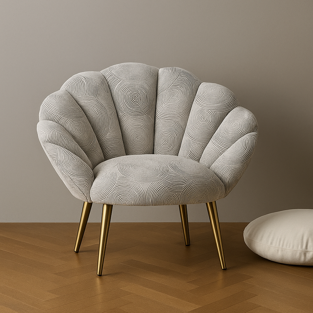 Modern scalloped velvet chair with light grey tiles effect fabric and gold legs on wooden floor.
