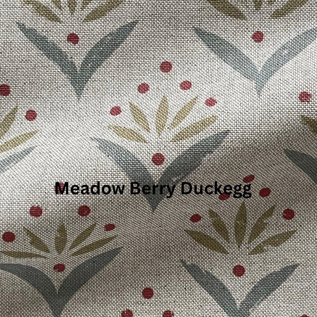 Fabric swatch with a pattern of leaves and berries labeled 'Meadow Berry Duckegg'.