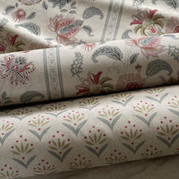 Thumbnail for Two rolls of fabric with floral and geometric patterns on a neutral background.