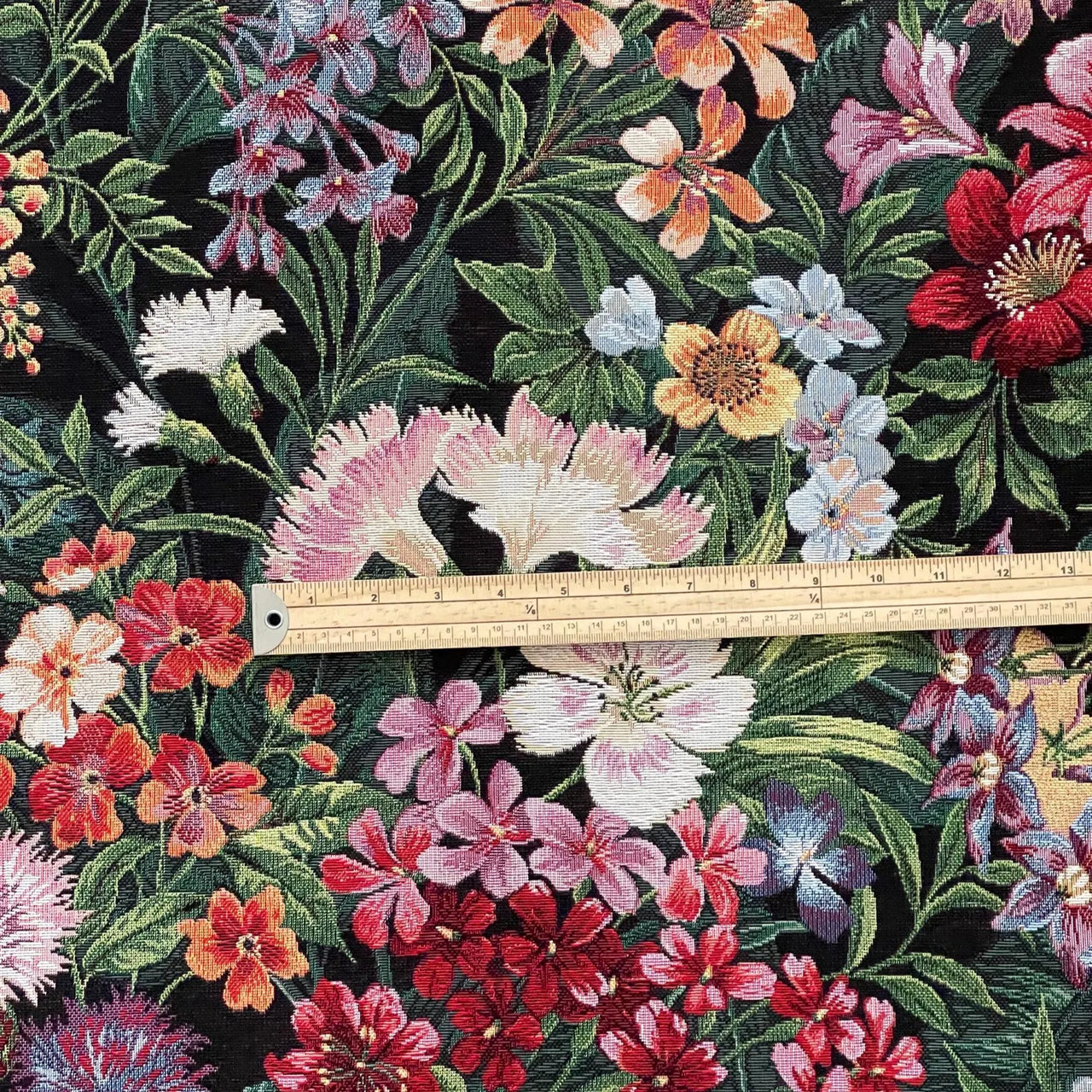 Upholstery tapestry fabric with dense garden blossoms and textured woven detail.