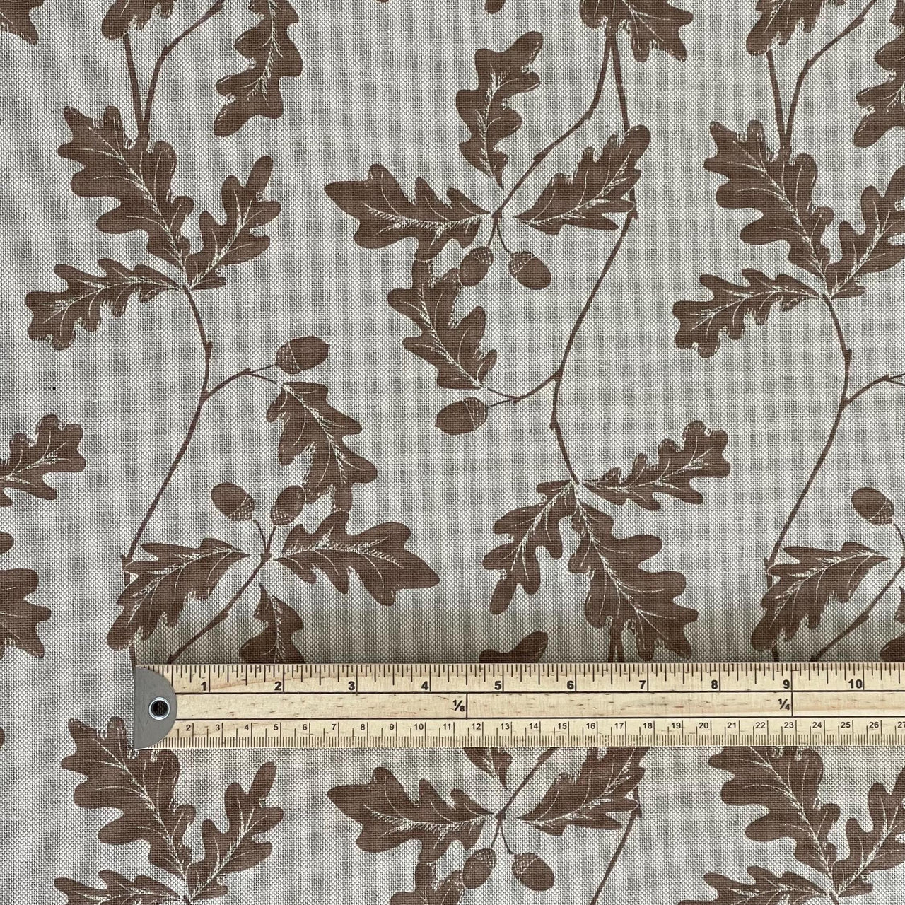 Beige botanical upholstery fabric with brown oak leaves and acorns – country cottage textile with nature-inspired pattern and visible scale