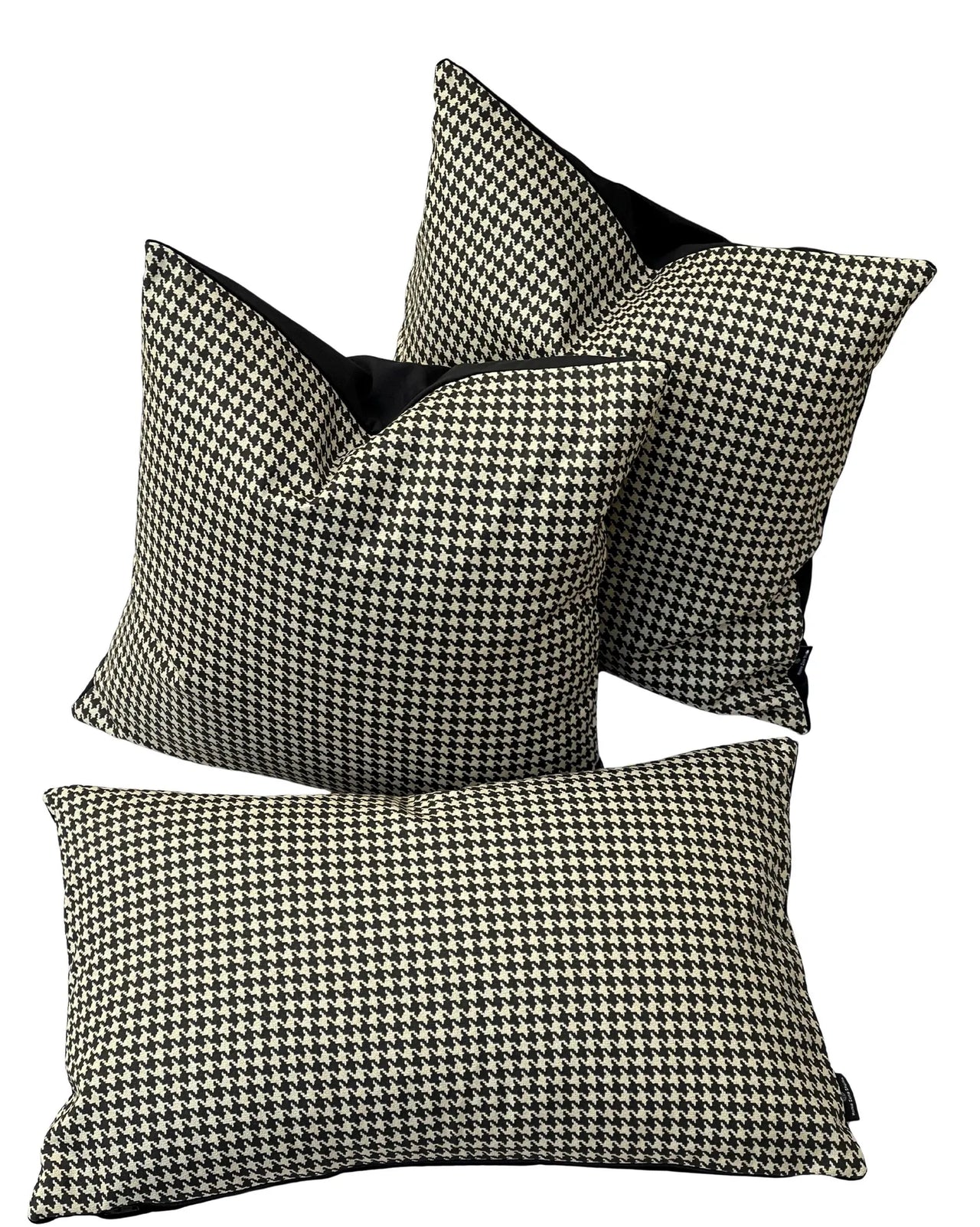 Set of houndstooth patterned pillows with black accents on a white background