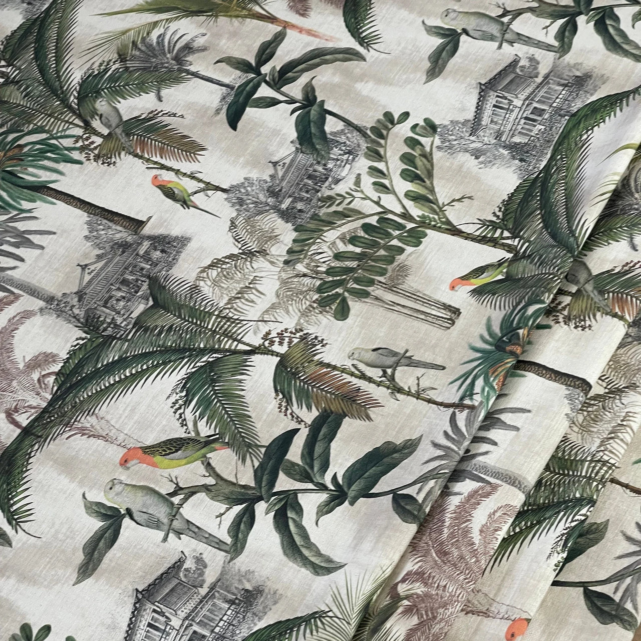 Jungle-themed fabric with green foliage, birds, and old buildings