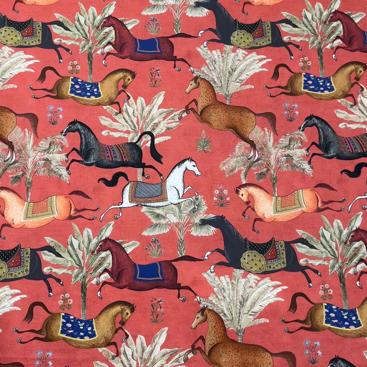 Patterned fabric with horses and trees on a red background