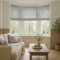 Thumbnail for Living room with floral-patterned roman blinds, beige sofa, wooden coffee table, and decorative elements.