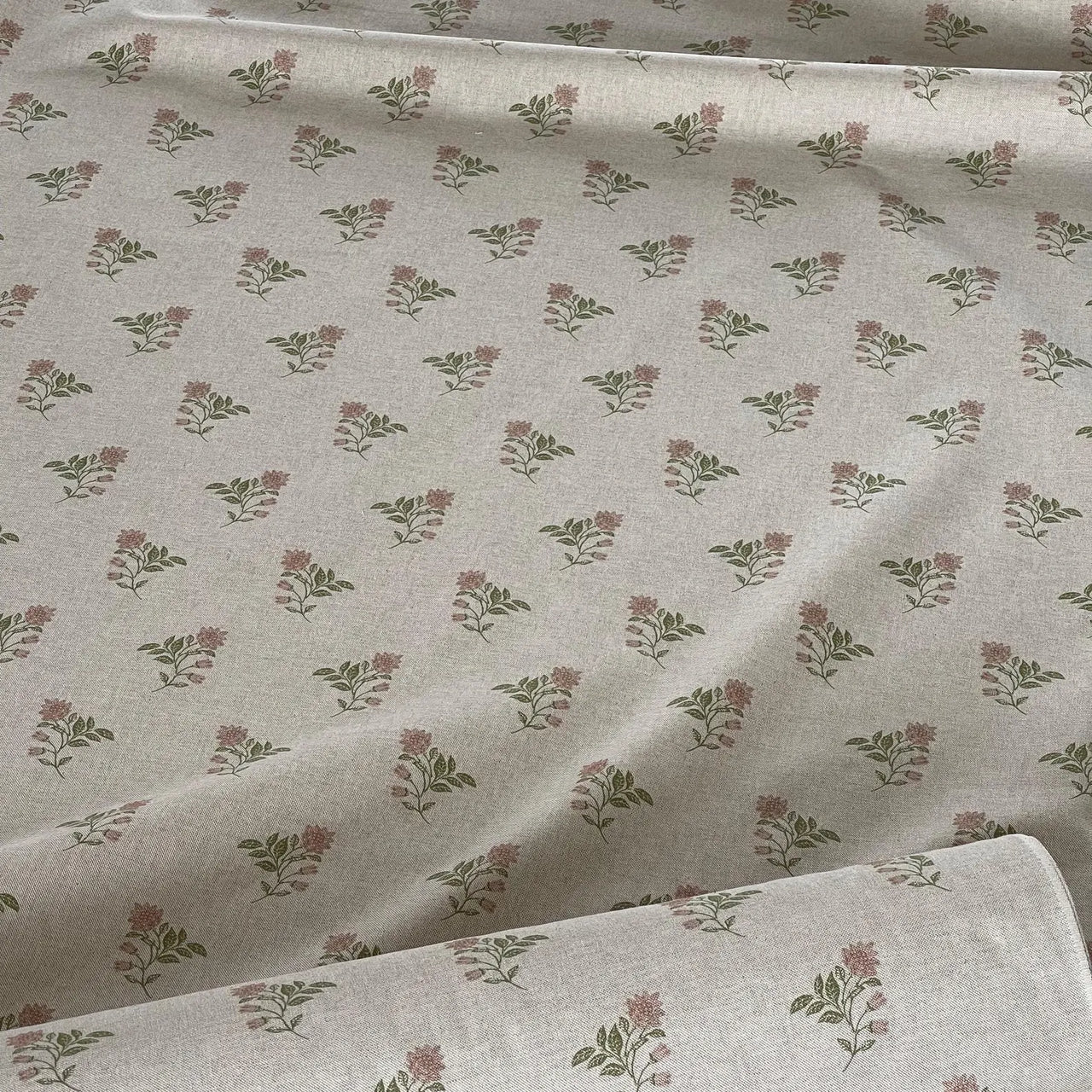 Floral patterned fabric with small flowers and leaves on a light background
