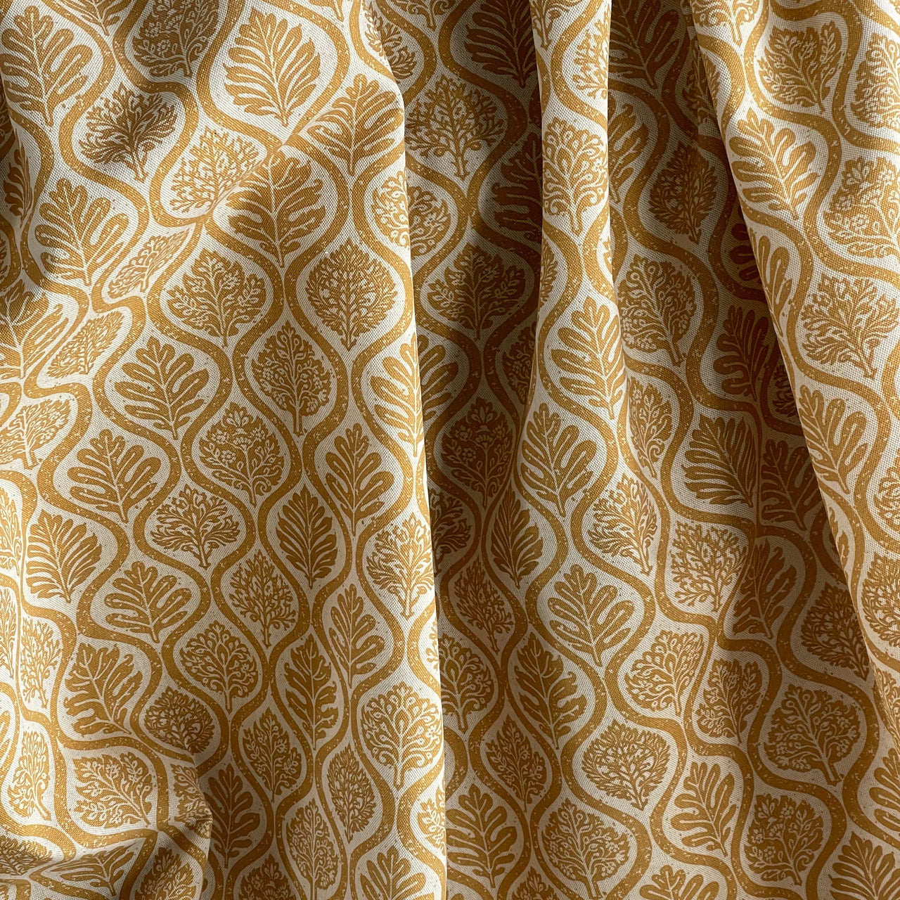 Mustard ogee textile with repeating leaf pattern detail
