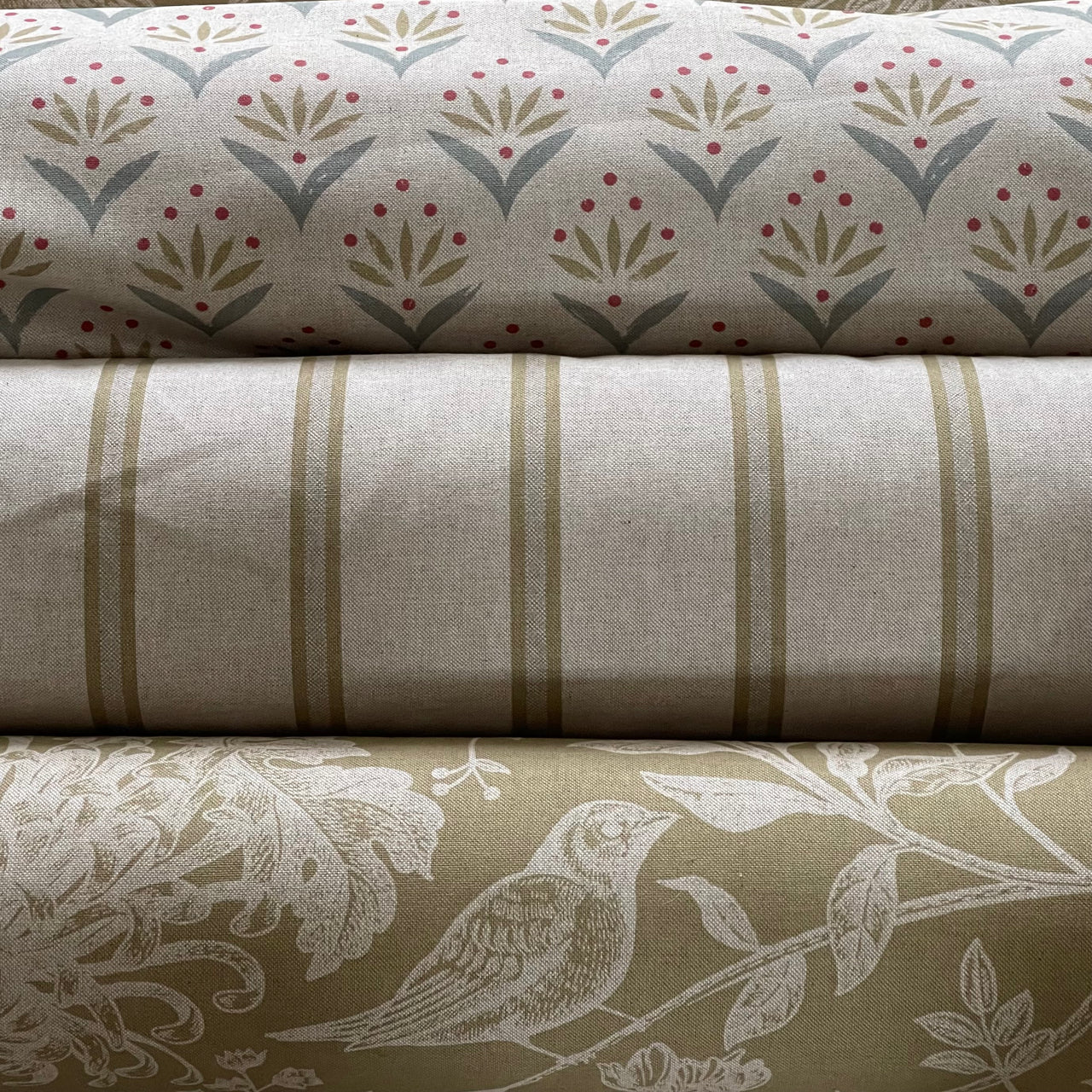 Three rolls of fabric with different patterns stacked on top of each other.