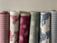 Thumbnail for Rolls of patterned fabric against a neutral background