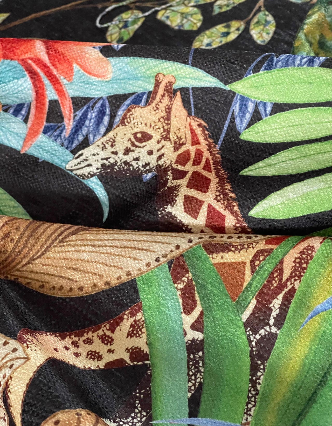 Botanical textile featuring leopards and greenery.