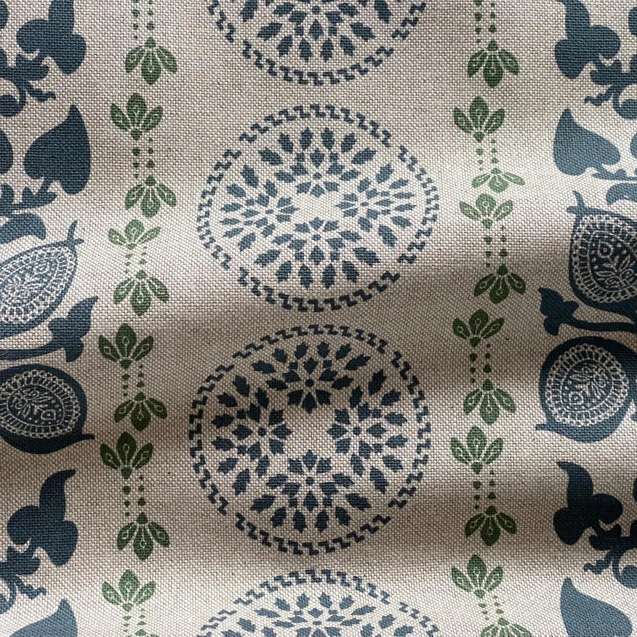 Navy blue botanical medallion fabric with green detailing on natural linen look background
