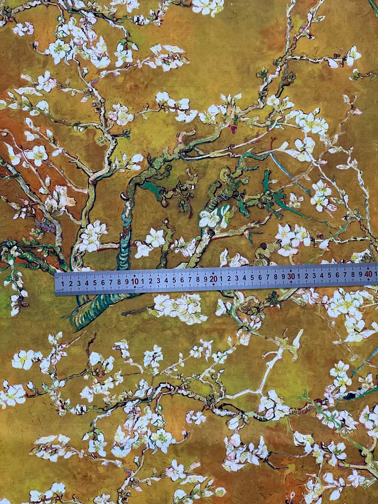 Floral patterned fabric with a ruler for scale on a textured background