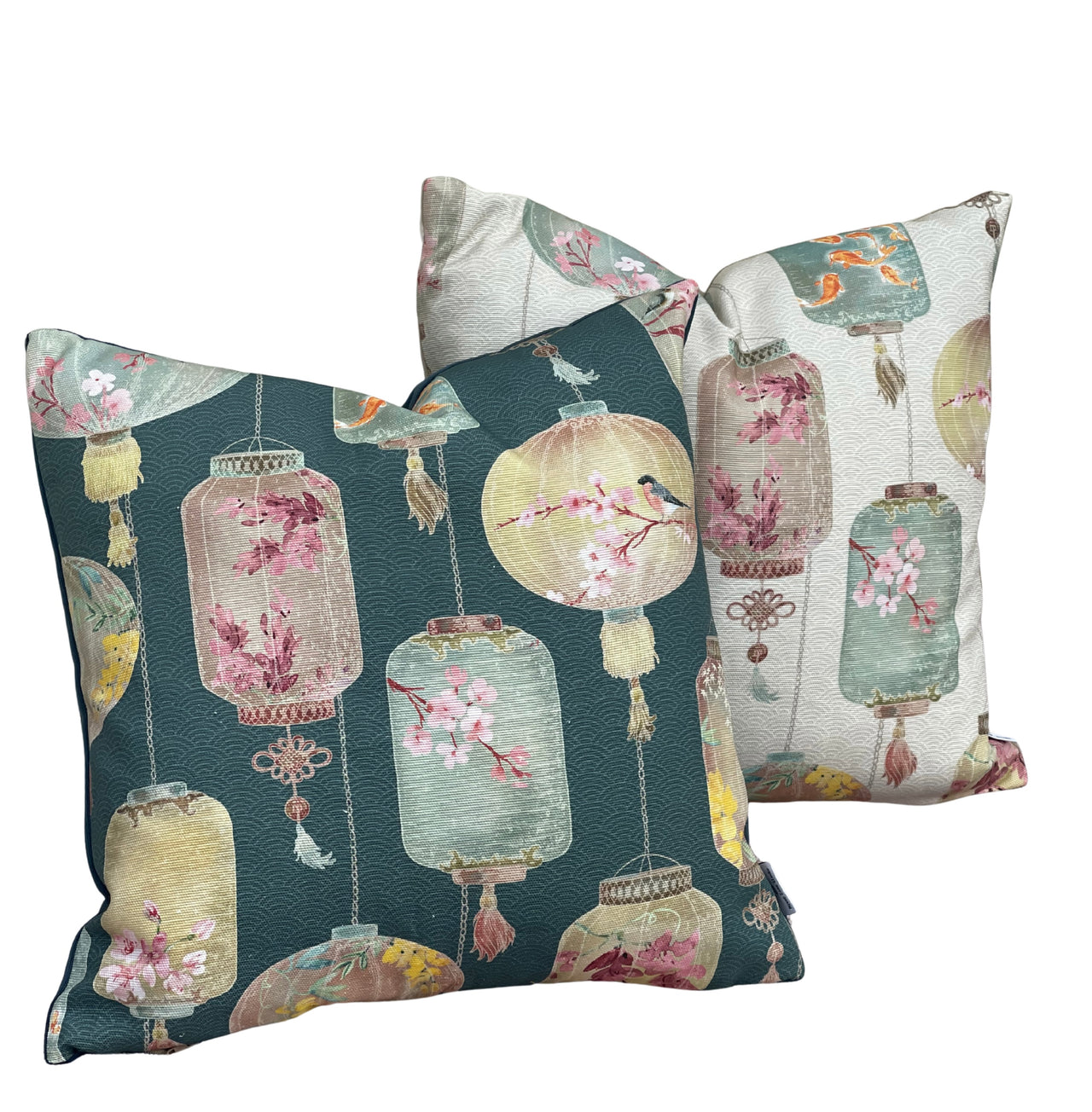 Coordinating ivory and dark teal green Asian lantern cushion covers with decorative pastel floral motifs and traditional hanging lantern designs.