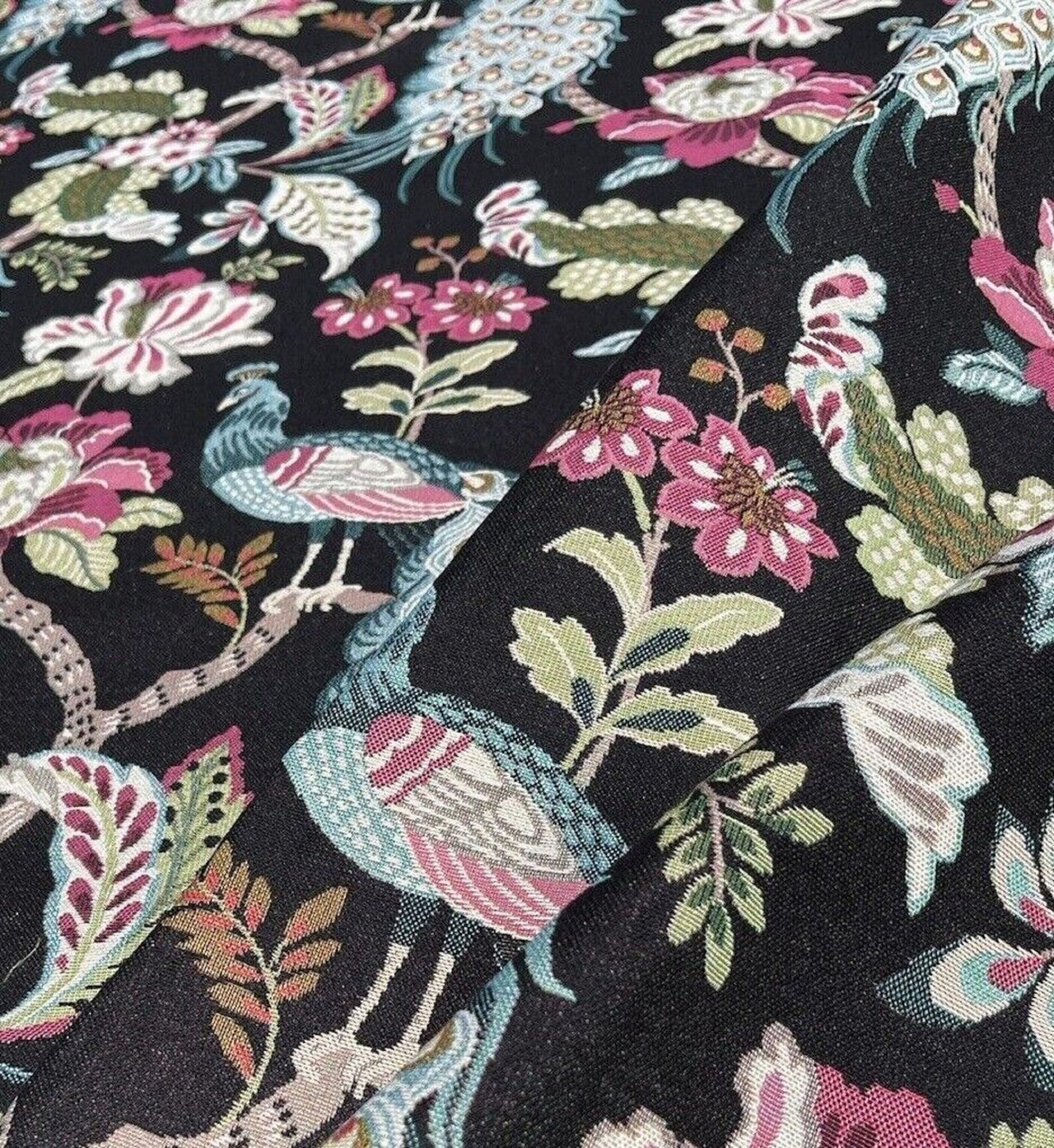 Fabric with floral and peacock pattern on a black background