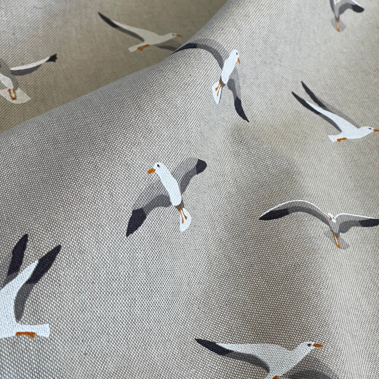 Fabric with a pattern of seagulls on a textured beige background